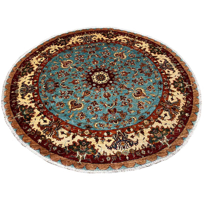 Round wool rug with a blue patterned field, floral ornaments, and a decorative border