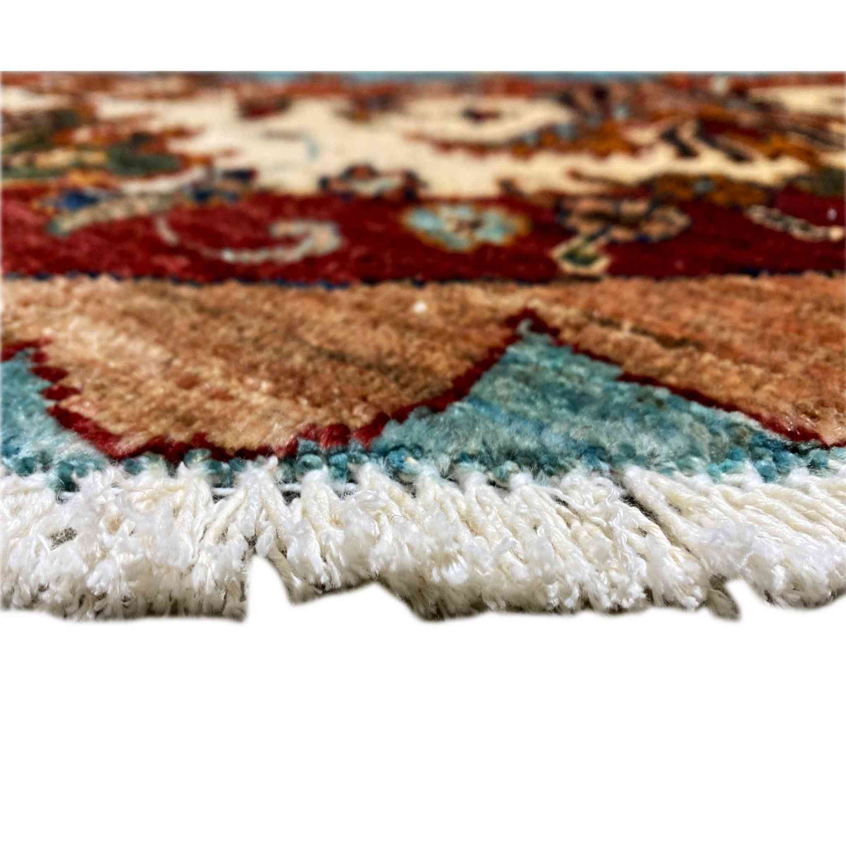 Rug edge with fringe: multicolored border at the top, soft wool pile at the bottom