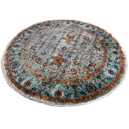Round rug with a light blue central medallion, colorful floral motifs and decorative border
