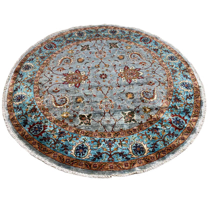 Round wool rug with a gray pile pattern, turquoise-blue border, and floral medallions