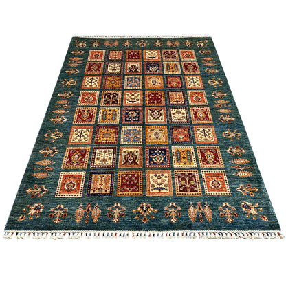 Blue-green rug with multicolored square patterns and a white fringed border