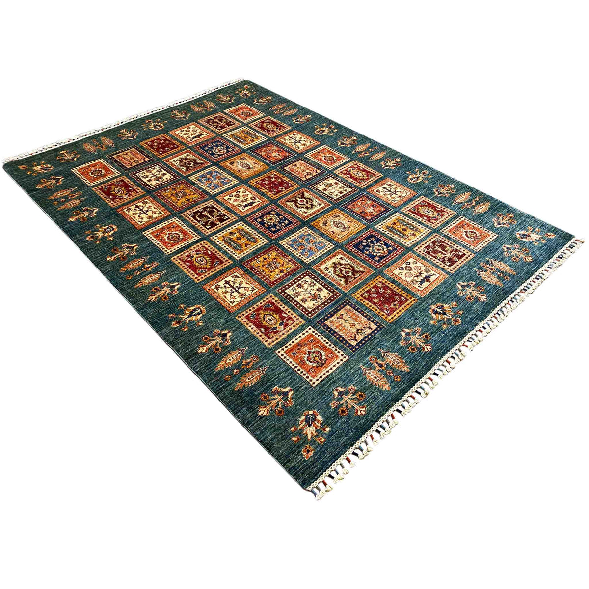Teal rug with geometric square patchwork, multicolored ornaments, white fringed border