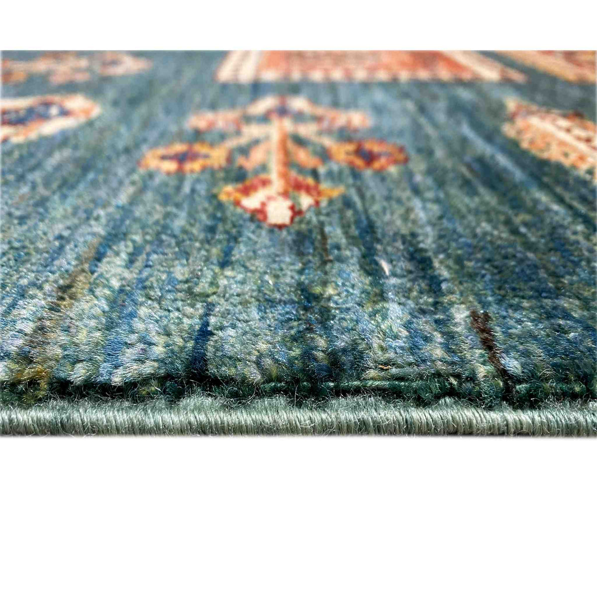 Blue-green rug with a dense pile, visible border, and multicolored pattern