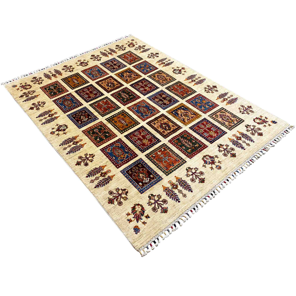 Rug in angled view: cream-colored surface with multicolored square motifs and fringes