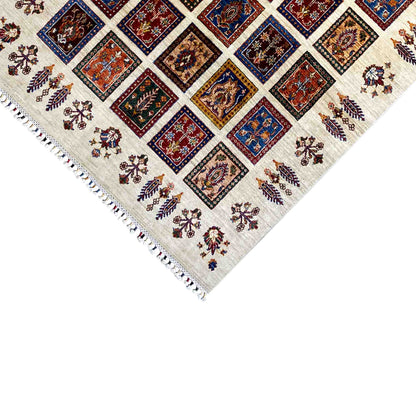 Close-up of the rug corner: fringed edges, a cream-colored base, and square motifs