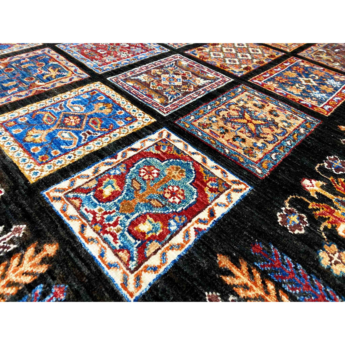 Close-up: colorful ornamental tiles arranged in a grid on a black wool carpet