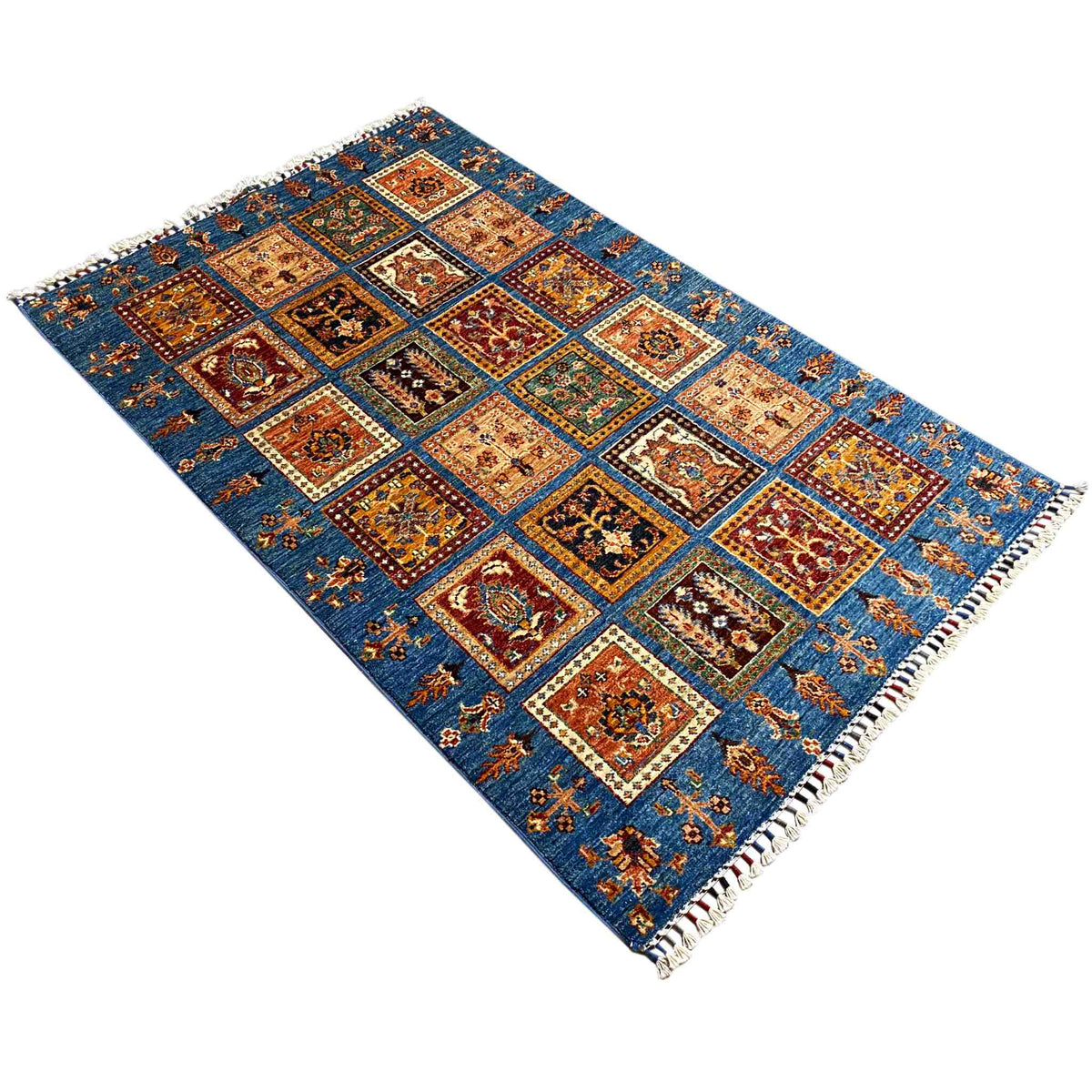 Rug with a blue background and an ornamental square pattern, arranged diagonally, with fringes