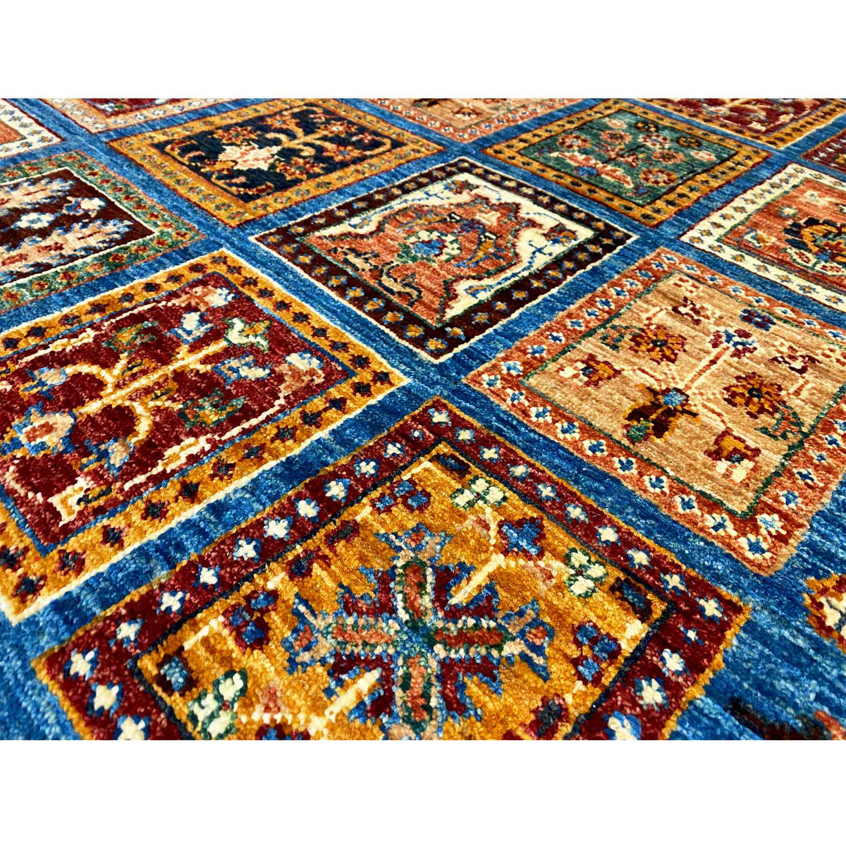Close-up of a rug: intersecting borders and colored squares on a blue background