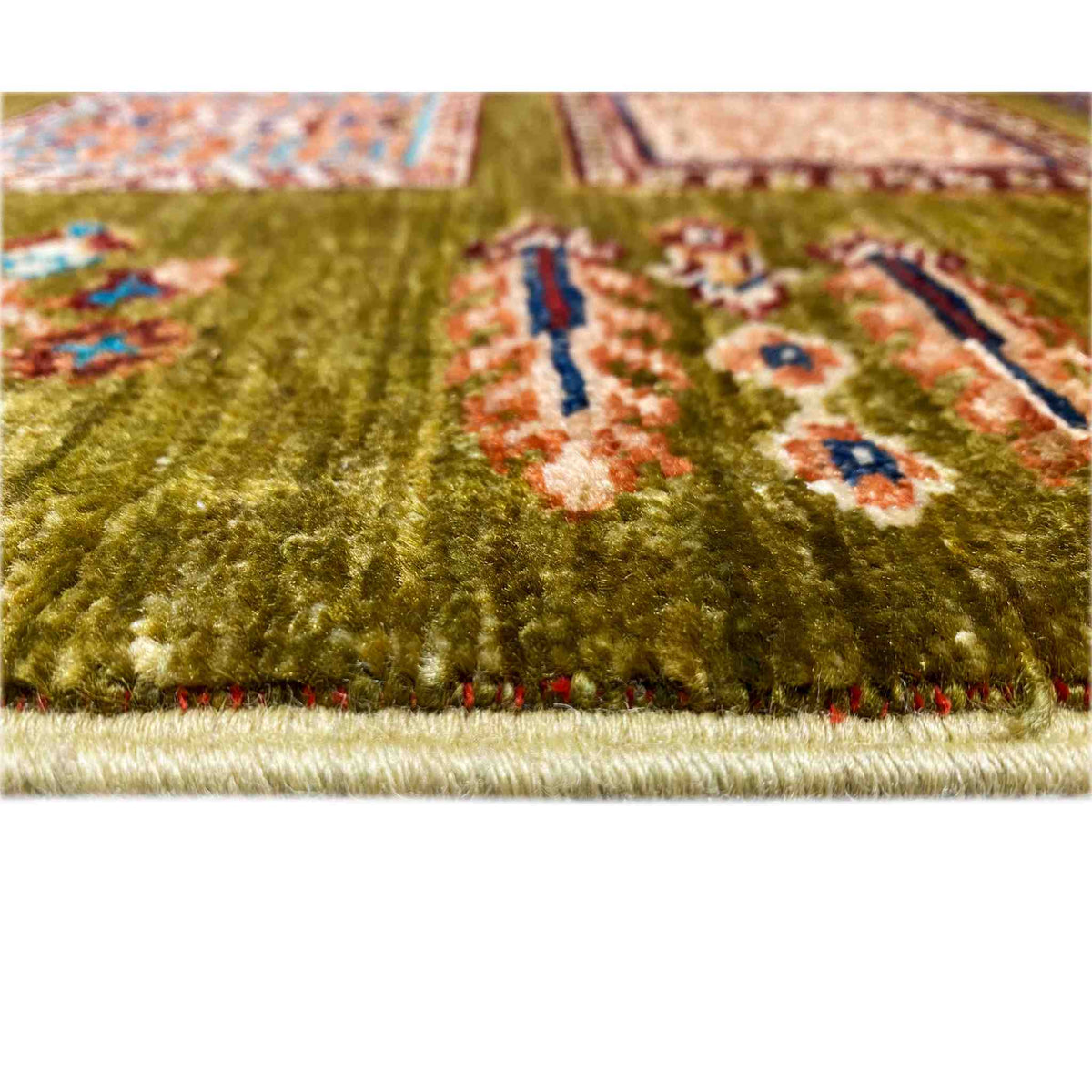 Close-up: olive-green Khorjin rug with a high pile and fringed trim