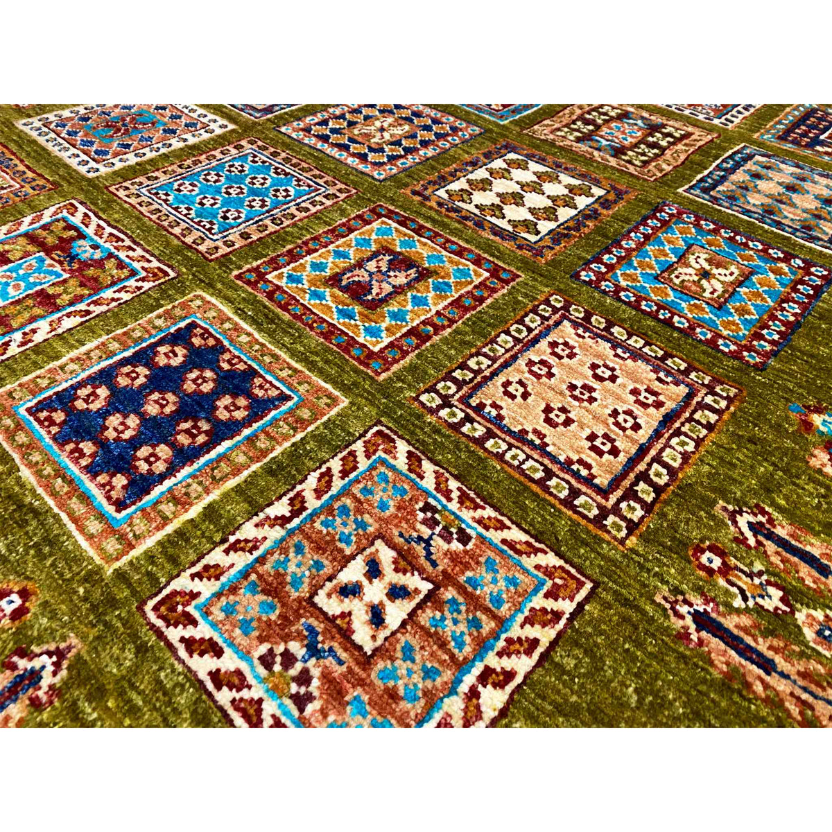 Detail of the olive-green wool rug: colorful squares with decorative edges