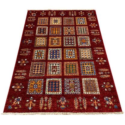 Afghan Khorjin wool rug, deep red, shown wide with a tile pattern and border.