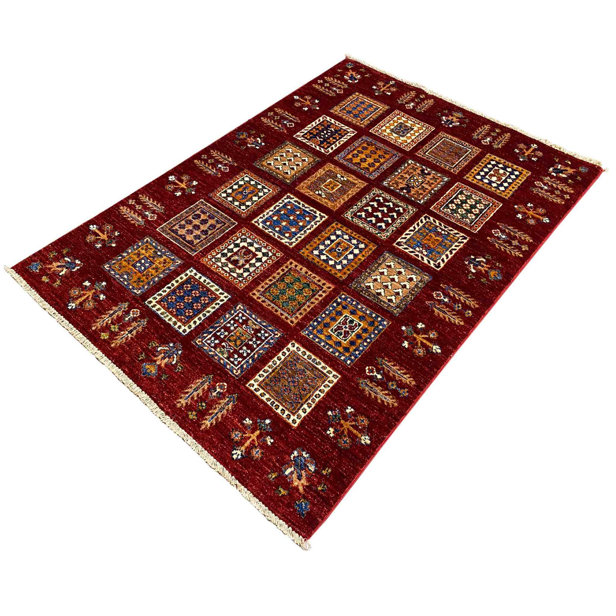 Afghan khorjin wool rug, deep red, photographed at an angle with tiles and a border.