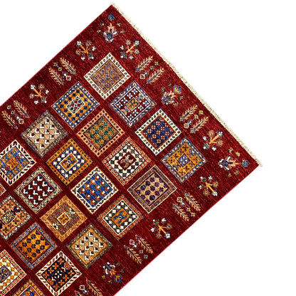 Afghan khorjin wool rug, deep red, front view with symmetrical squares and border.