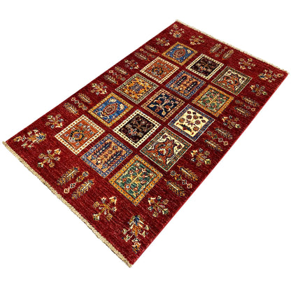 Deep red wool rug with a central grid pattern of colorful squares and fine borders