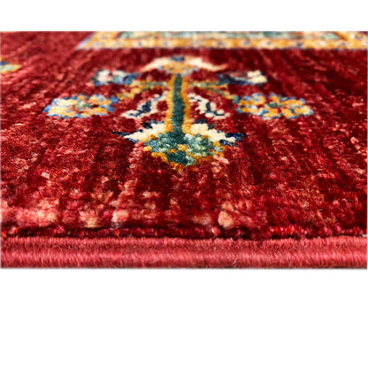 Close-up: deep red wool rug with a colorful medallion and uniform pile texture