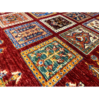 Close-up of the carpet surface: deep red with embossed ornamental corners in blue, green, and yellow