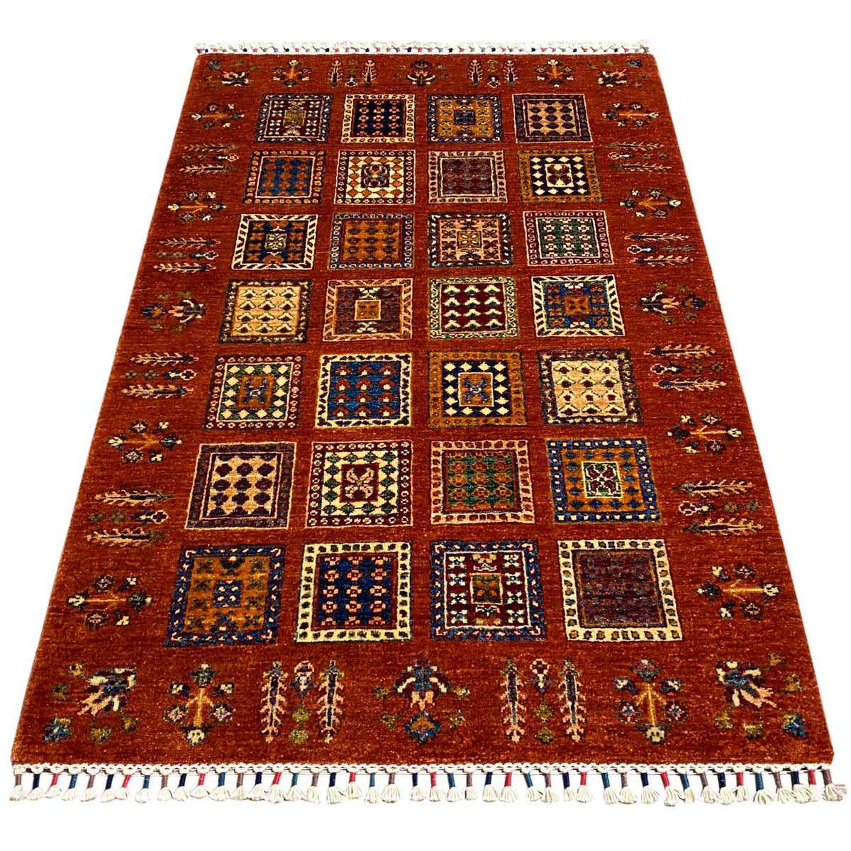 Brick-red wool rug with colorful tile patterns and bound fringes, rectangular.