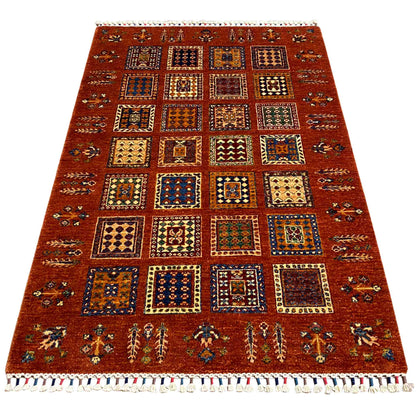 Brick-red wool rug with colorful tile patterns and bound fringes, rectangular.