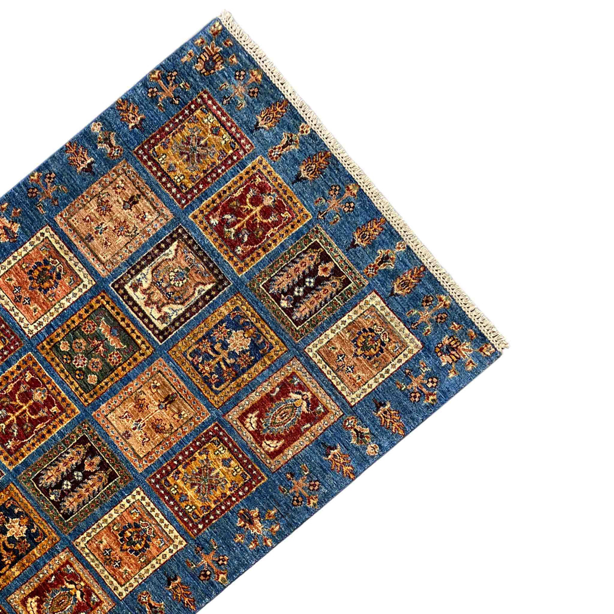 Rug corner: blue Khorjin rug with square ornamental panels and beige border fringe