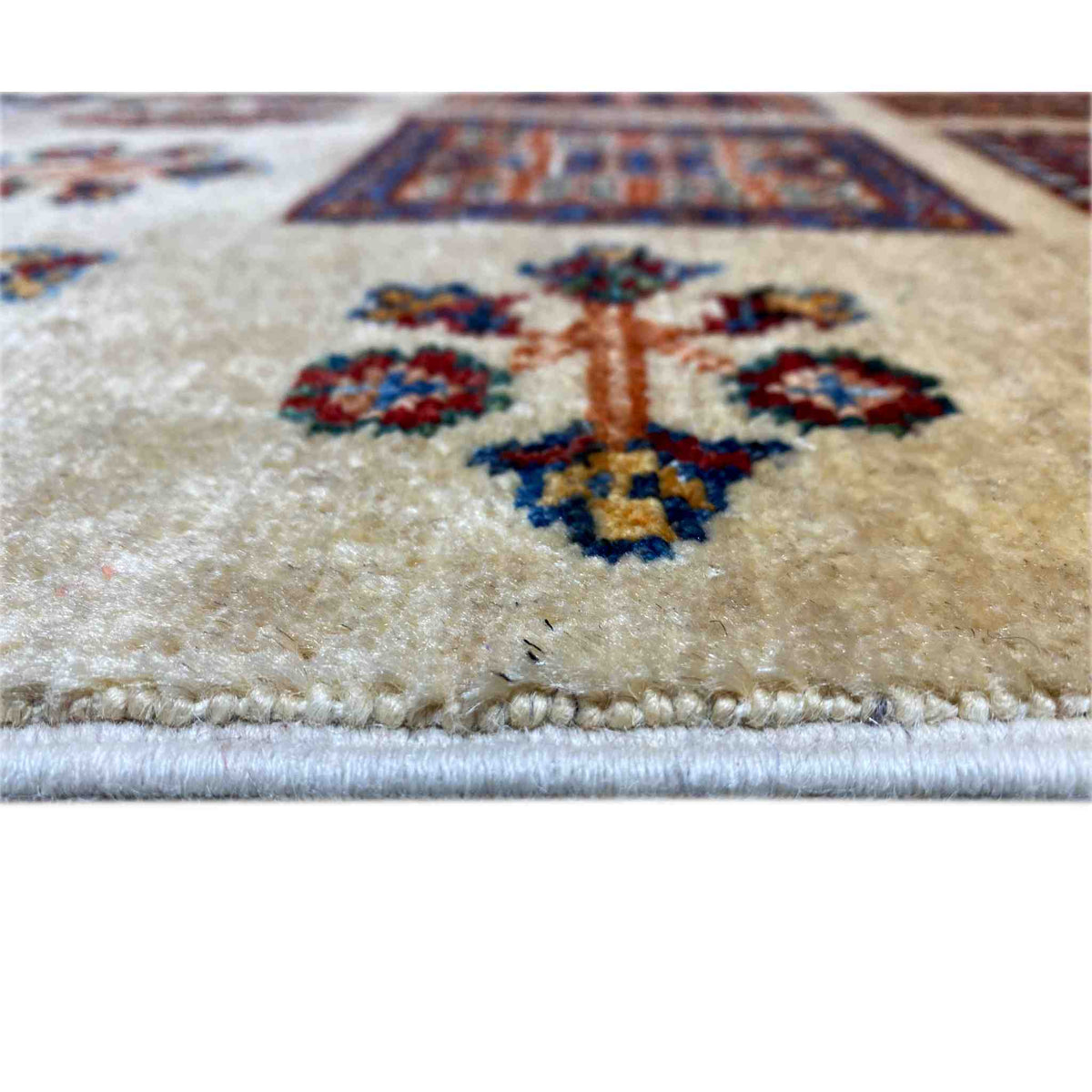 Close-up of the beige Afghan Khorjin rug: pile with colorful floral ornaments, with a border