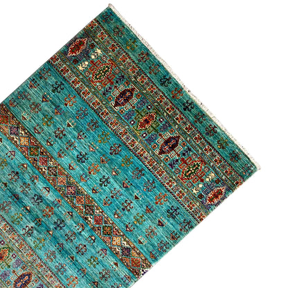 Carpet in petrol blue with decorative band patterns and a multicolored central section