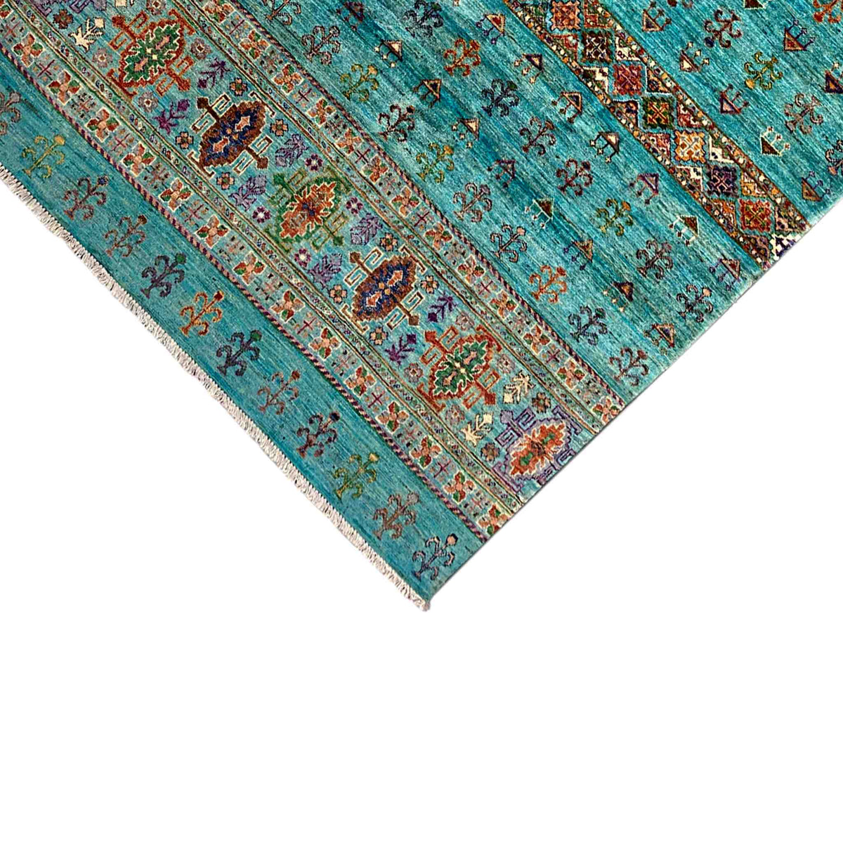 Corner of a petrol-blue rug with a finely embroidered border and delicate fringes