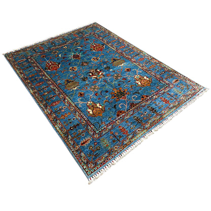 Afghan Khorjin rug in blue with floral medallions, photographed diagonally