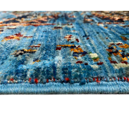 Close-up of the blue carpet pile with multicolored patterns and a textile edge
