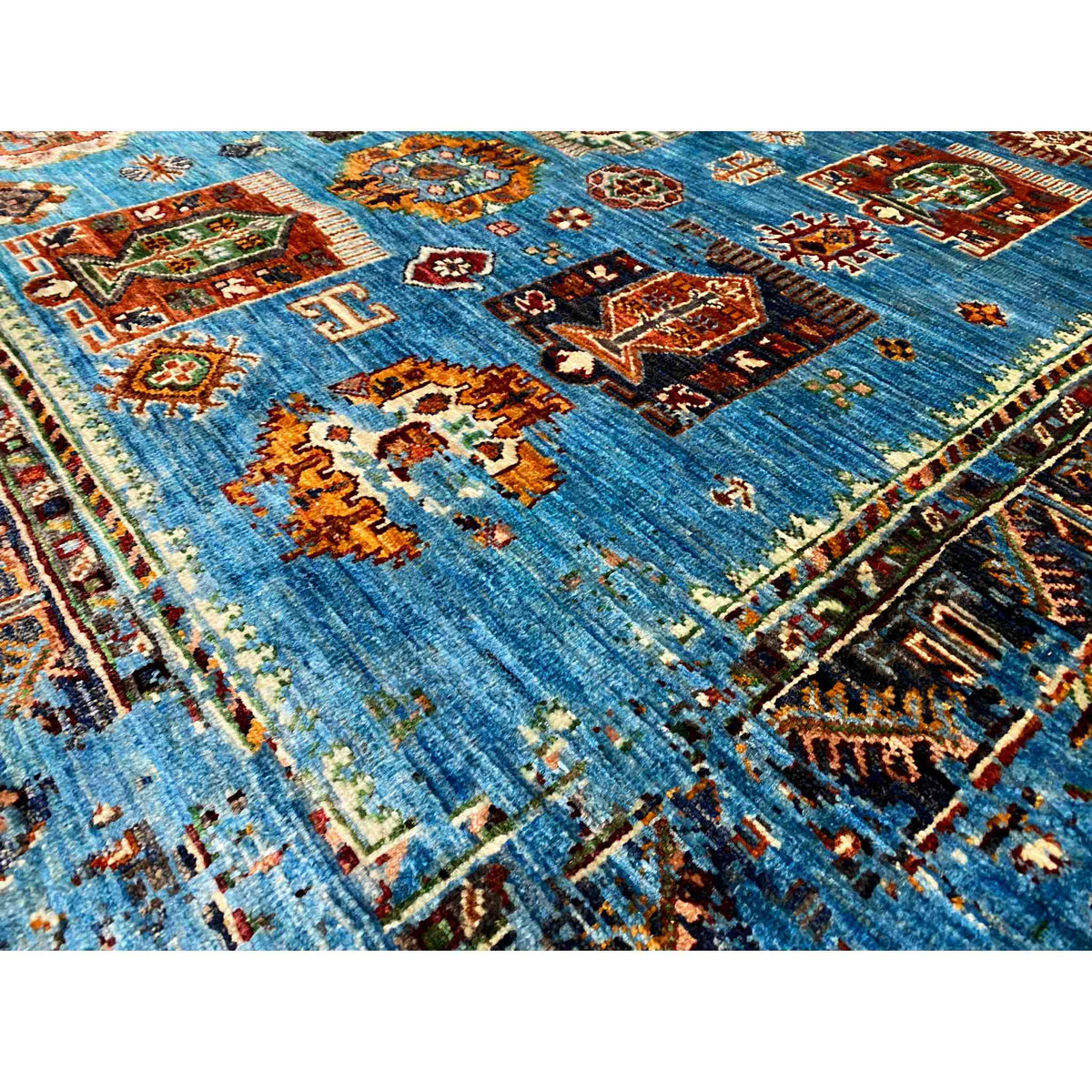 Close-up view of a blue carpet section with colorful ornaments and border lines