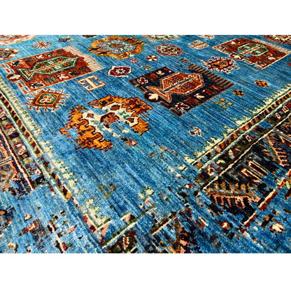 Close-up view of a blue carpet section with colorful ornaments and border lines
