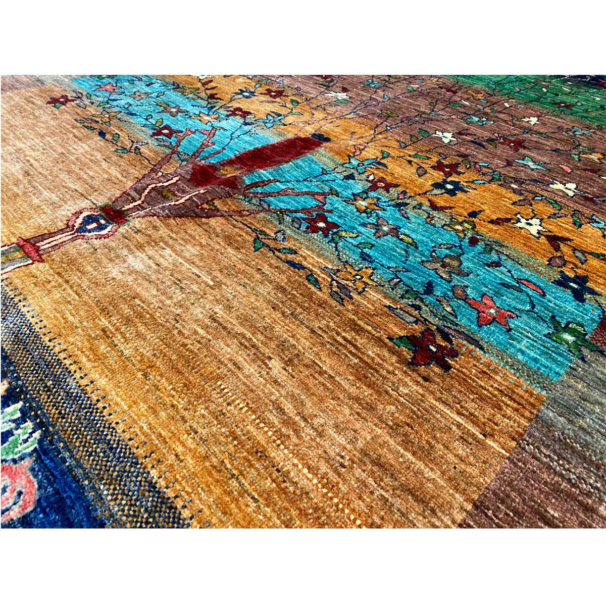 Close-up of the carpet pattern: tree fork, turquoise background, and golden tones