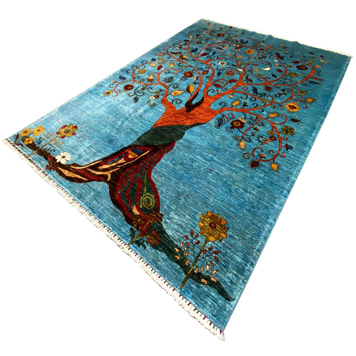 Blue rug with tree illustration, red-clothed figure, and colorful flowers across the surface
