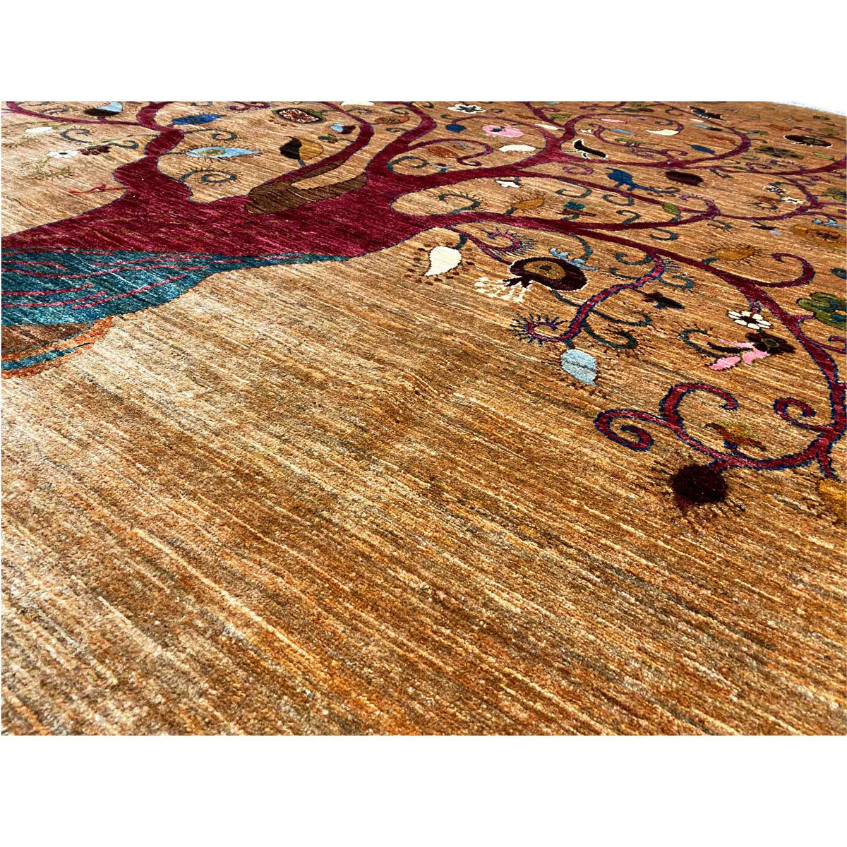 Close-up of carpet: tree and floral ornaments on beige-brown, colorful details