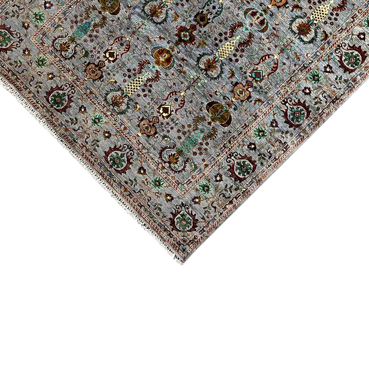 Close-up of a carpet edge: gray base with an ornamental border and fringe