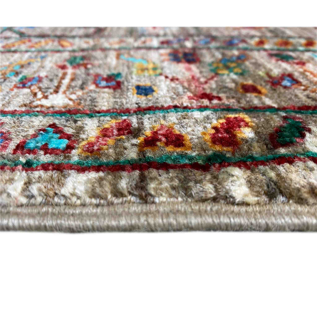 Close-up of runner rug: brown pile, colorful floral motifs, bound edge