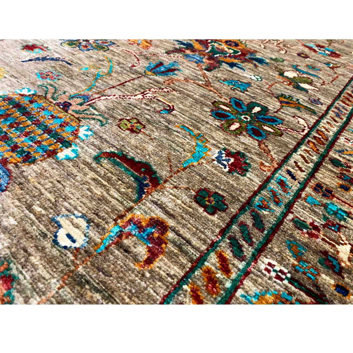 Close-up of a runner rug: brown base, turquoise/red ornaments, woven texture