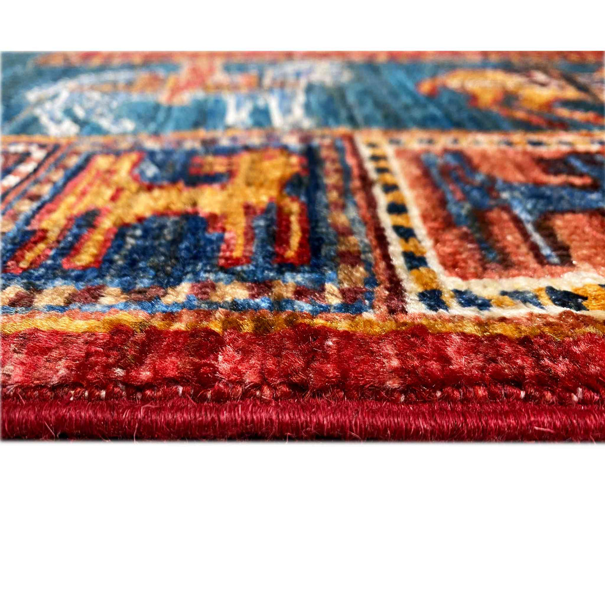 Close-up: red carpet border and fringe, blue pattern with red accents