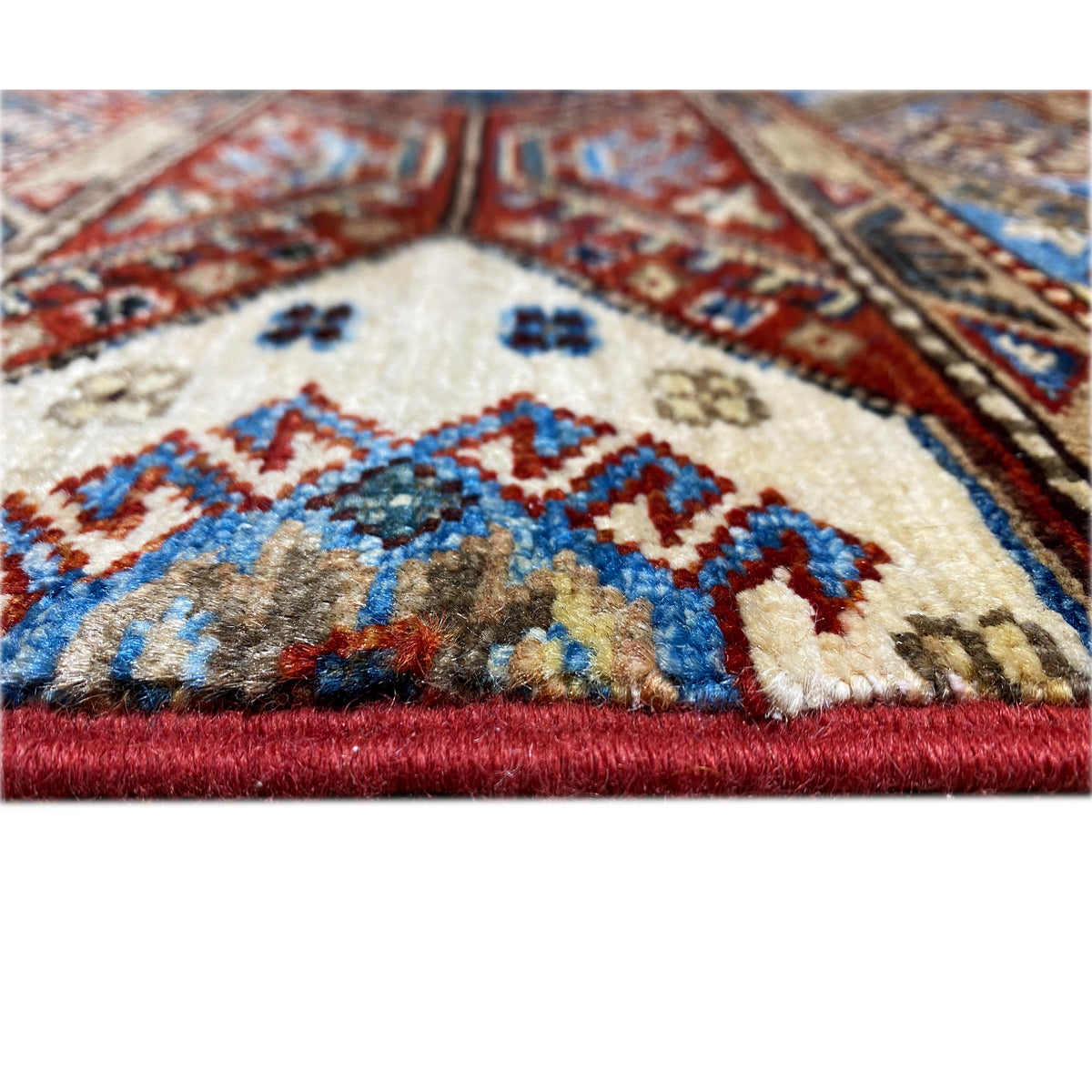 Khorjin rug detail at the edge: geometric patterns, short fringes, and dense pile
