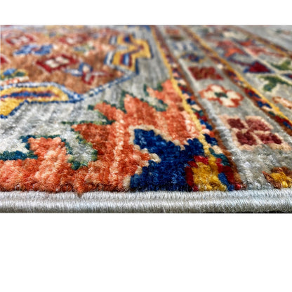 Close-up: knotted pile of the Khorjin carpet with colorful motifs on light gray fabric