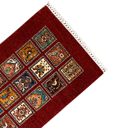 Corner of the hand-knotted Khorjin runner: red square pattern with white overcast edging