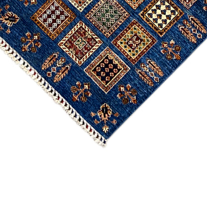 Khorjin runner corner with fringed trim and geometric patterns on a blue background