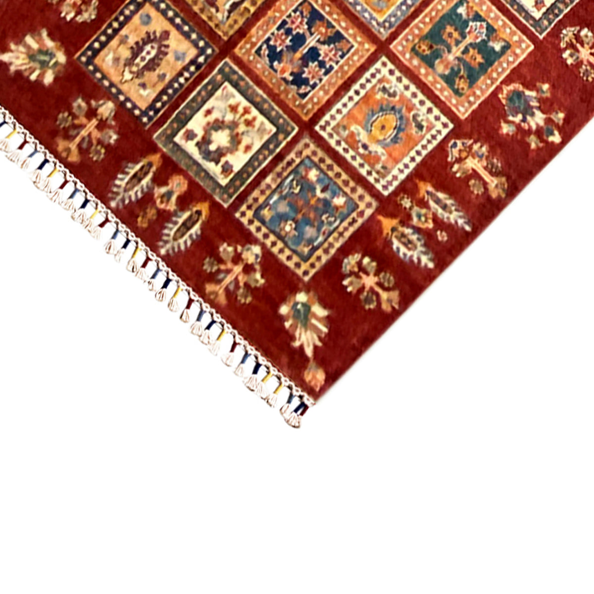 Corner section of the table runner: red background, colorful squares, and white fringe.