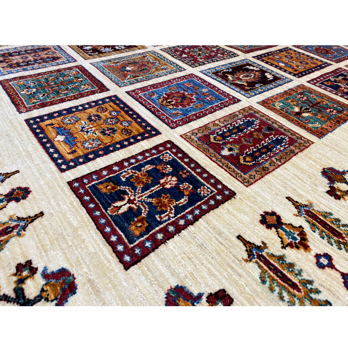 Khorjin rug detail: square ornaments in blue, red, and gold on a light background.