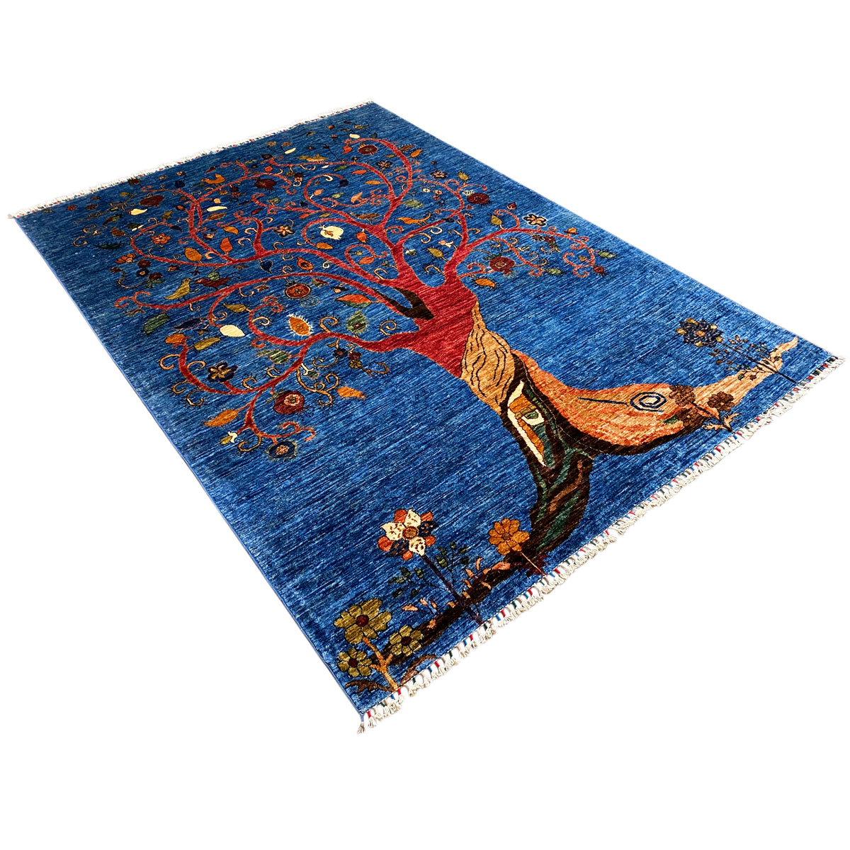 Hand-knotted rug, diagonal view: tree of life with a red trunk and colorful vines