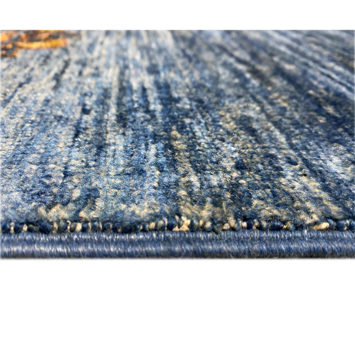 Carpet detail at the edge: blue fabric with a fine border and short fringe