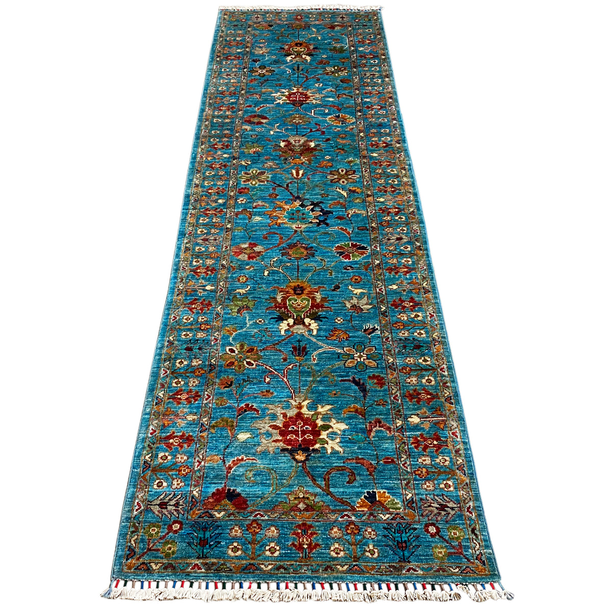 Hand-knotted blue runner with a large ornamental pattern, narrow border, and fringes