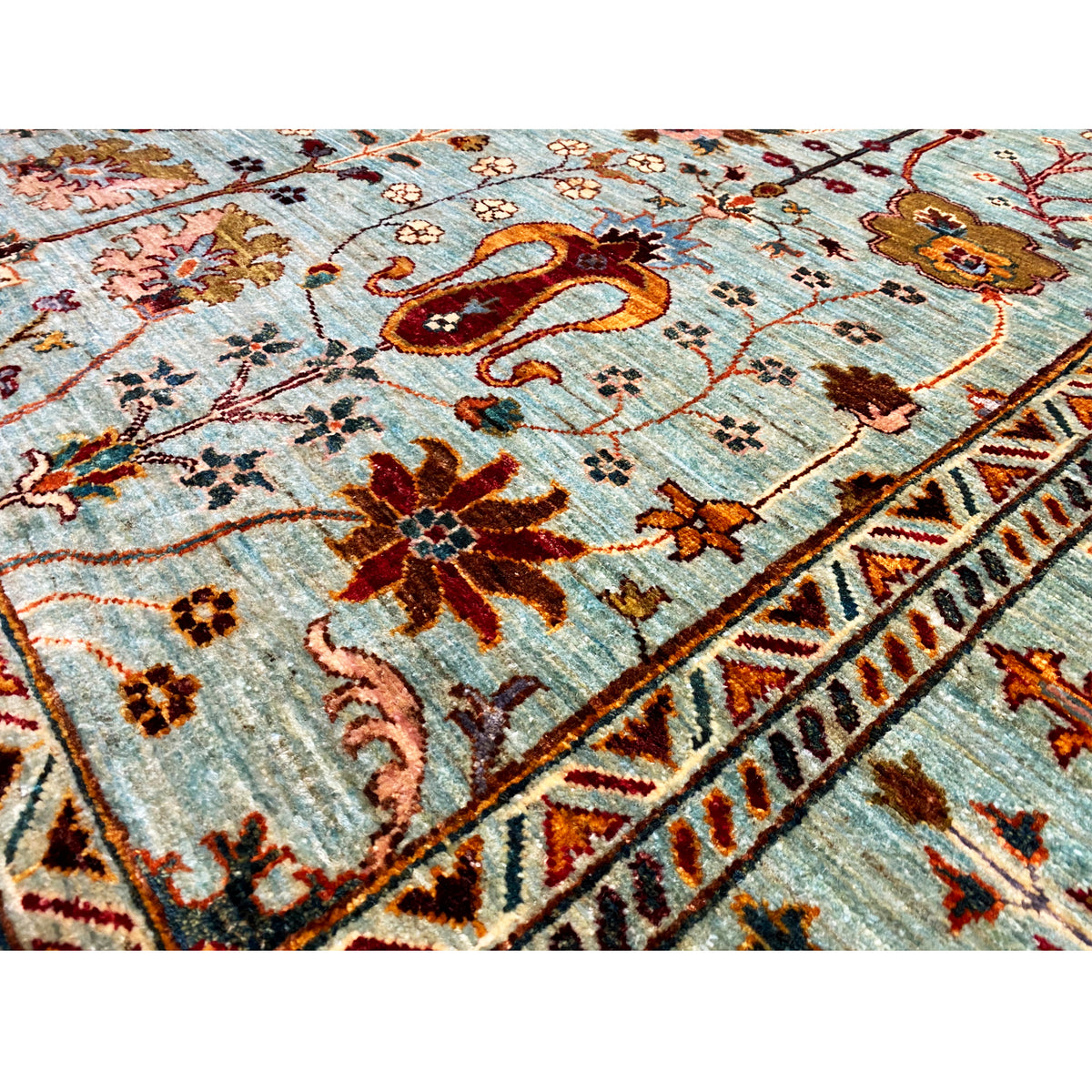 Detail of the Khorjin rug: turquoise pile with brown-red flowers, birds, and decorative lines