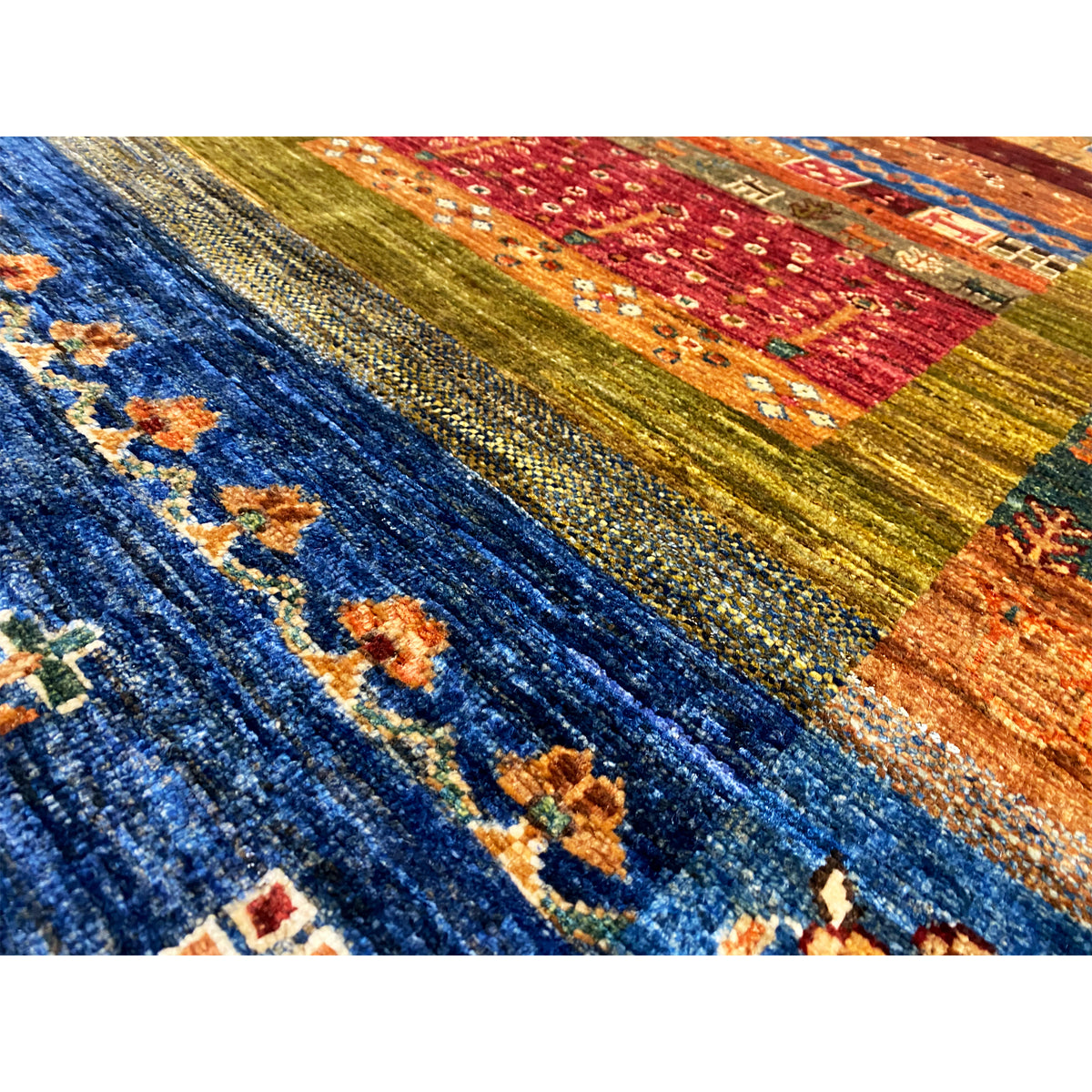 Close-up of a carpet surface: blue field with geometric motifs and yellow-brown accents