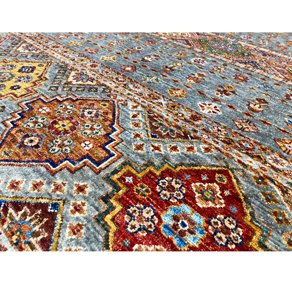 Close-up of the geometric rug pattern in gray with red, blue, and yellow elements