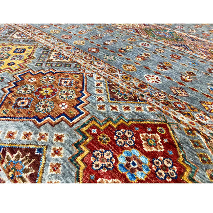 Close-up of the geometric rug pattern in gray with red, blue, and yellow elements